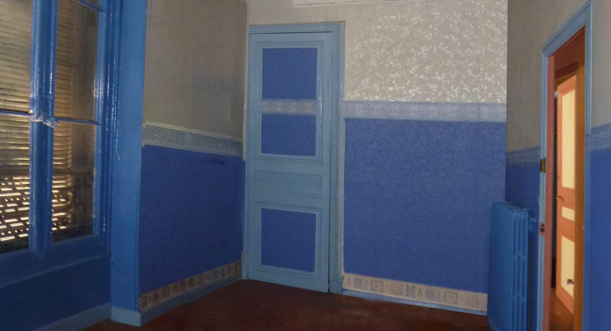 Une pièce avec un mur bleu, un rideau et une porte peinte en bleu clair.