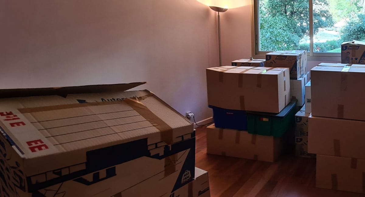 Des cartons empilés dans une pièce, probablement en cours de déménagement.