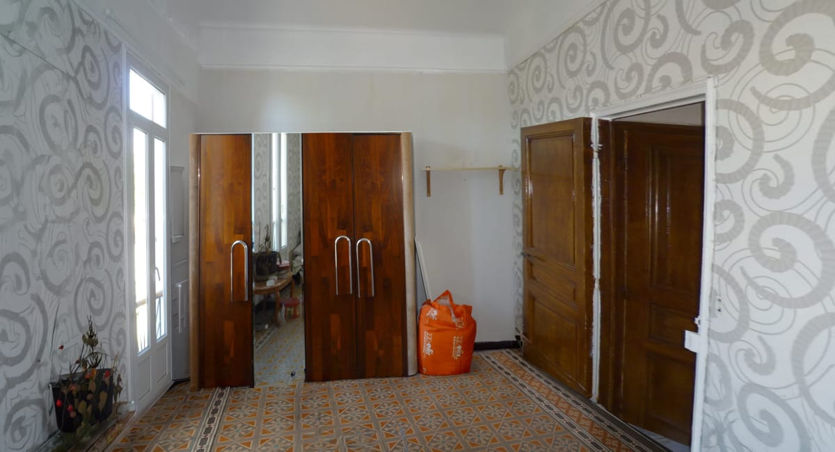 Intérieur d'une pièce avec des murs décorés de motifs floraux et des portes en bois.