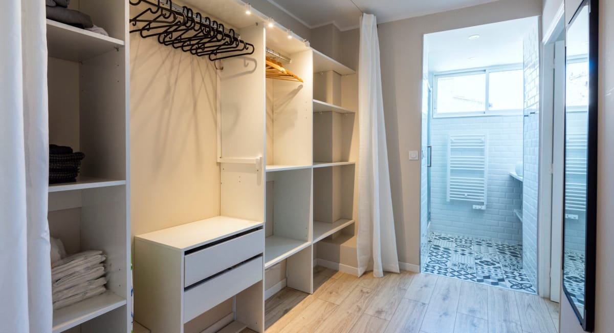 Une chambre d'amis avec un placard, une salle de douche et un décor moderne.