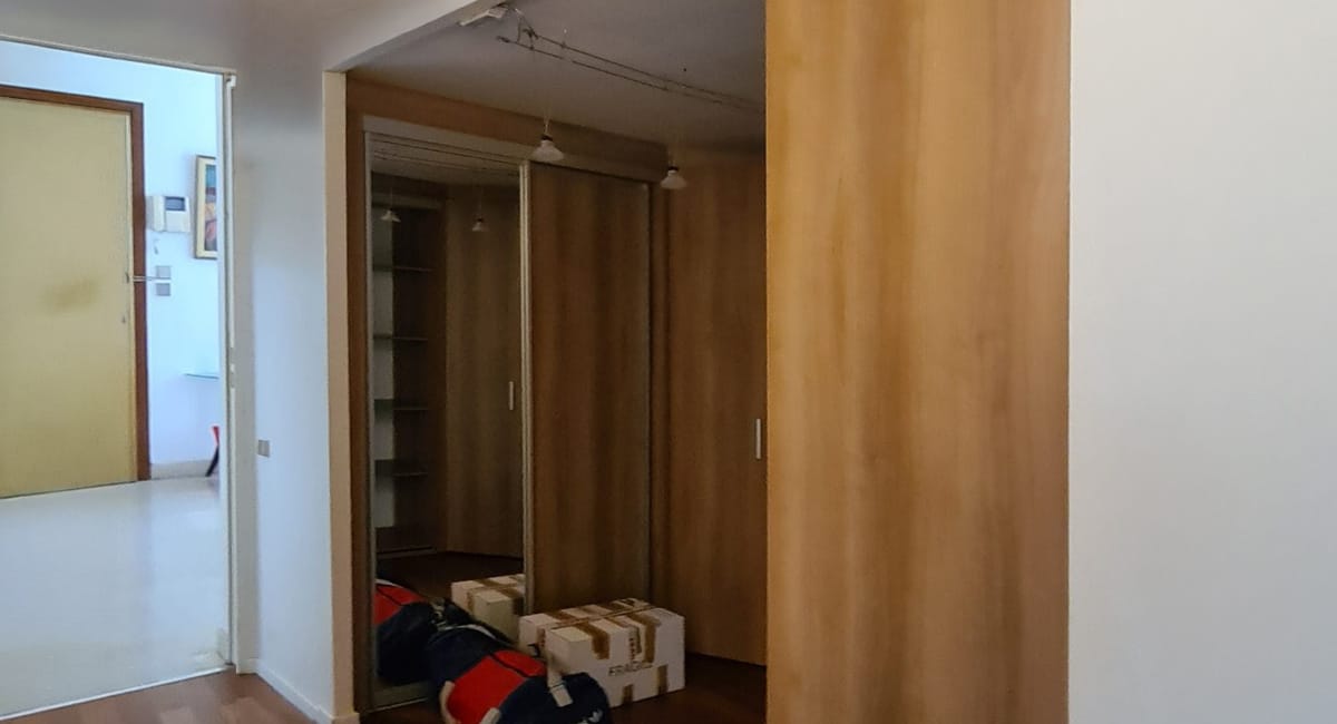 Vue d'un dressing avec des étagères et des boîtes, dans un appartement moderne.