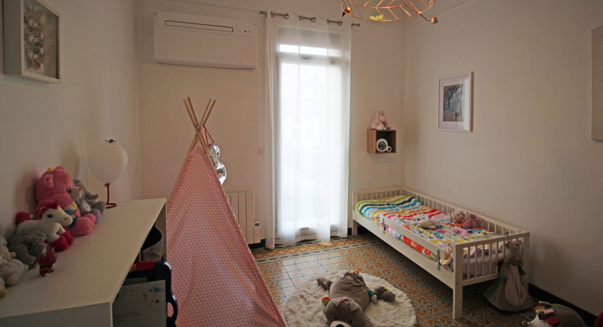 Une chambre d'enfant lumineuse et décorée avec des jouets et un tipi.