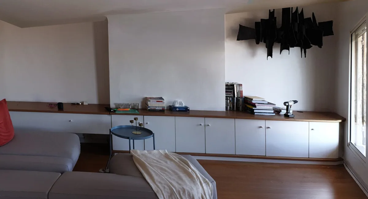 Intérieur d'une pièce avec un meuble blanc, des livres et un décor noir.