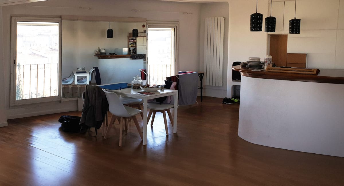 Intérieur d'une salle à manger lumineuse avec une table et des chaises blanches.