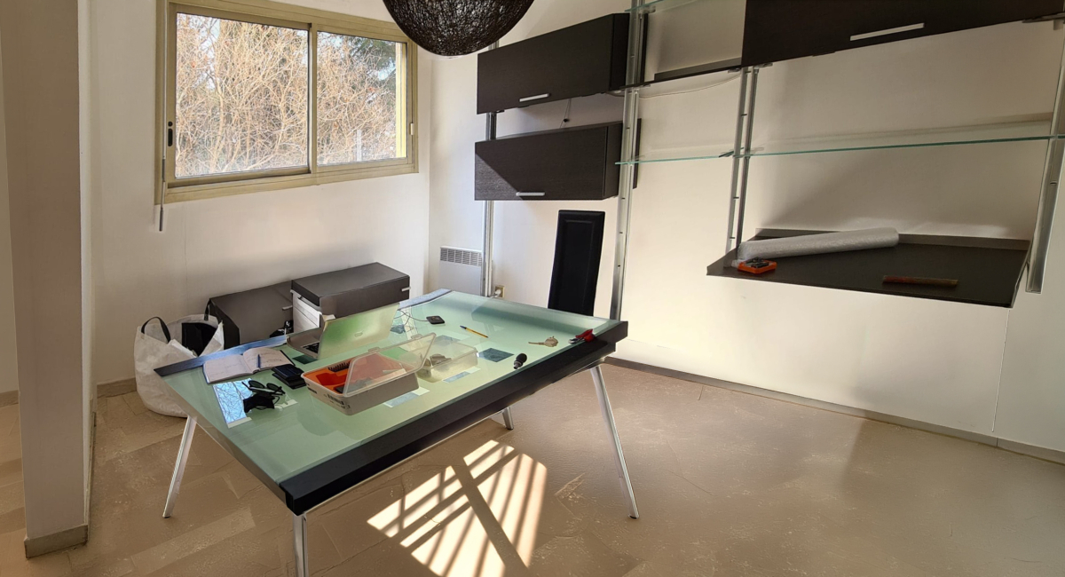 Bureau moderne avec étagères ouvertes dans un espace de travail lumineux.