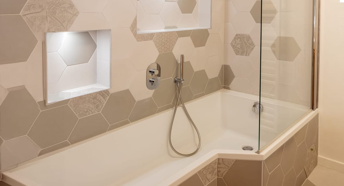 Baignoire moderne avec douche à l'italienne et carrelage décoratif élégant.