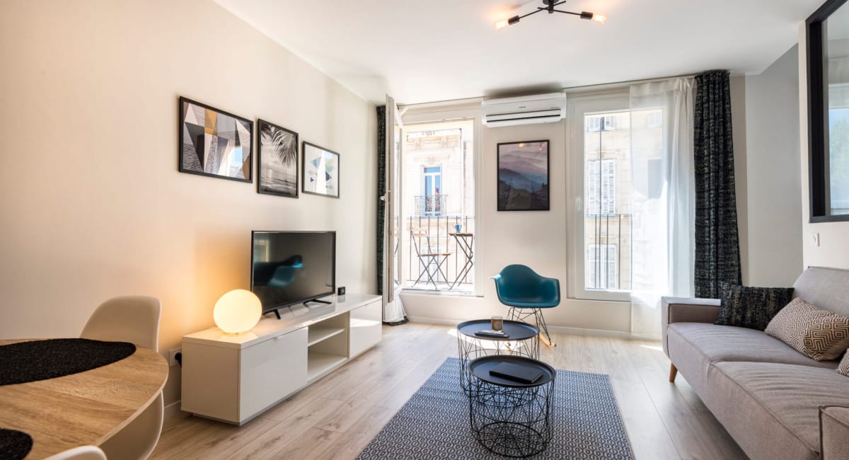 Un salon cosy et moderne avec un canapé, une table basse et une télévision.