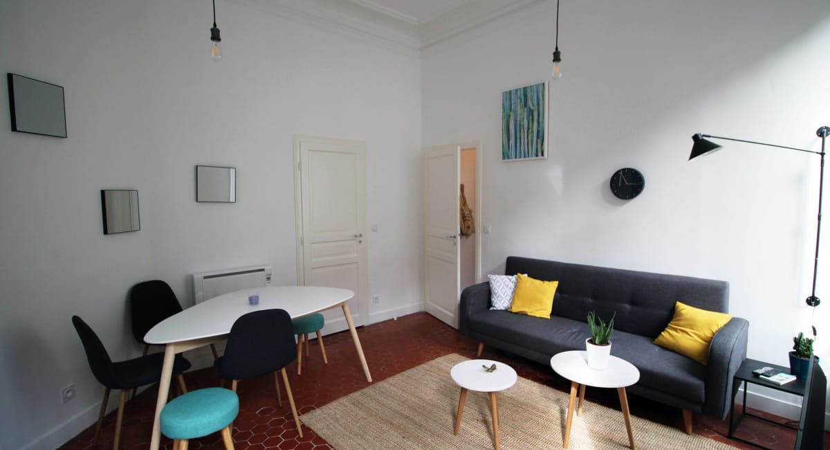 Intérieur d'un salon moderne et lumineux avec des meubles simples et des décorations colorées.