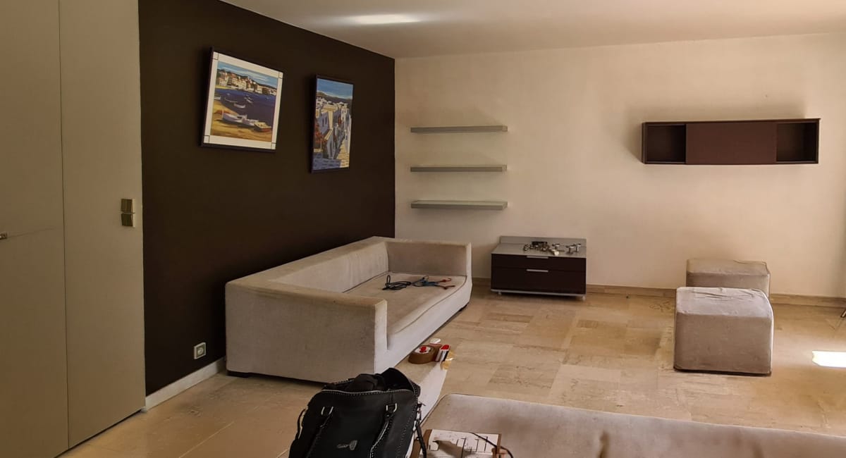 Intérieur d'une chambre avec un canapé, des étagères et un placard.