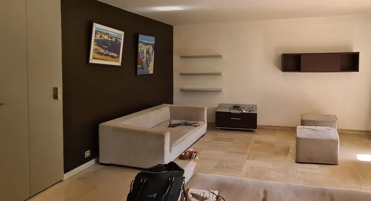 Intérieur d'une chambre avec un canapé, des étagères et un placard.