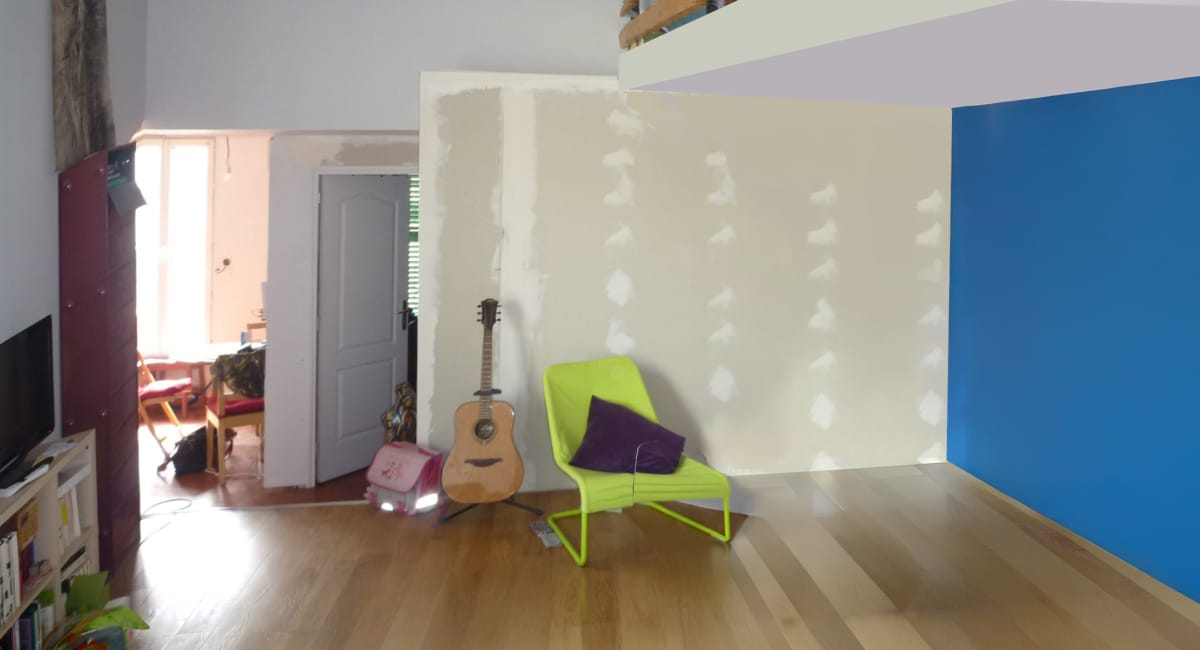 Mur en cours de placage, avec un fauteuil vert et un mur bleu en arrière-plan.