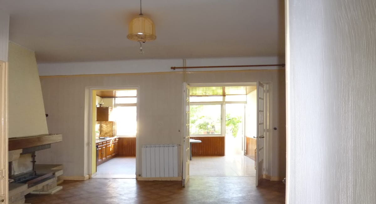 Intérieur d'une maison ancienne avec des pièces à rénover et une vue sur le jardin.