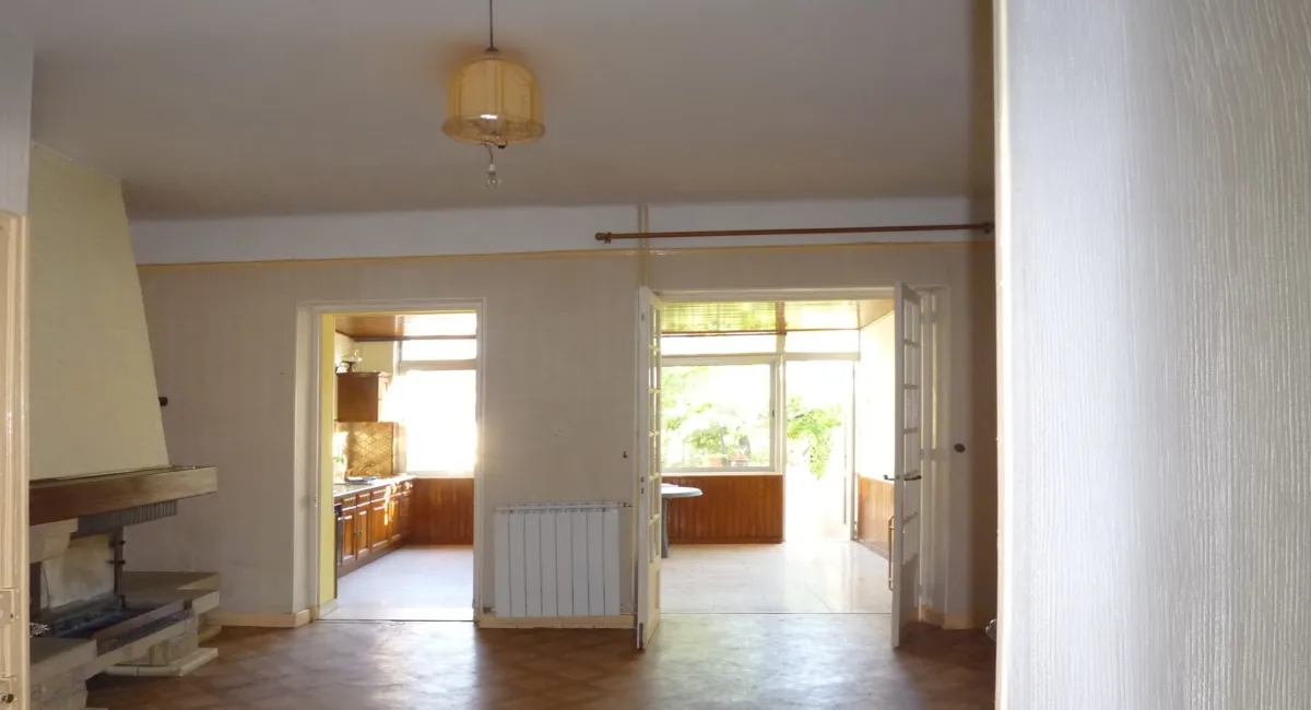 Intérieur d'une maison ancienne avec des pièces à rénover et une vue sur le jardin.