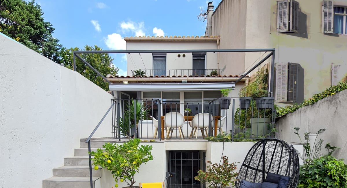 Terrasse extérieure d'une maison avec mobilier de jardin et citronniers.