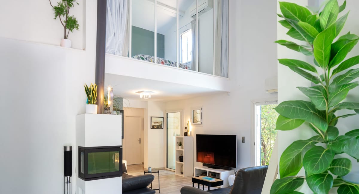Intérieur moderne et lumineux d'un appartement avec mezzanine et plantes.