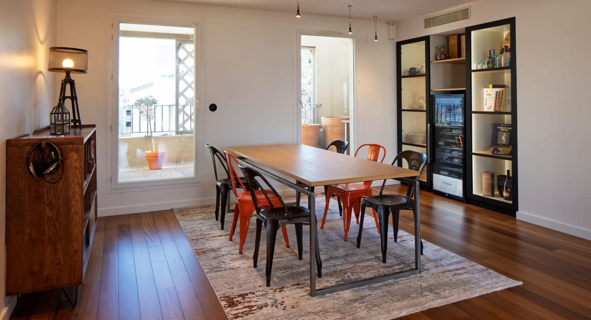 Une salle à manger moderne et chaleureuse avec une table en bois et des chaises rouges.