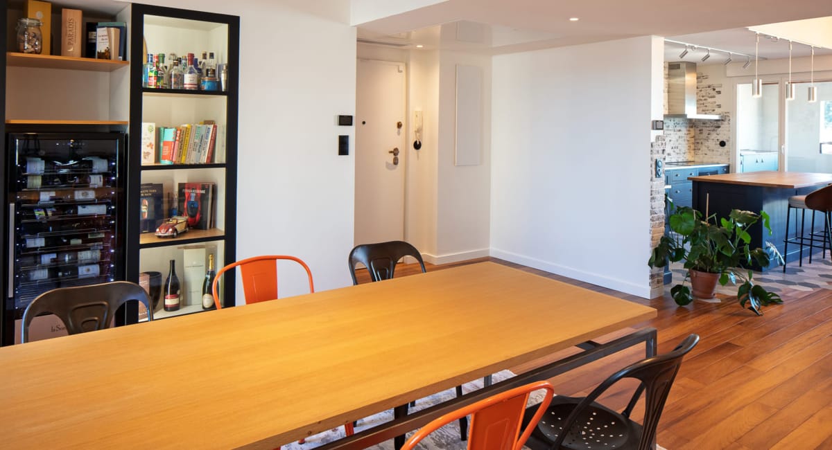 Intérieur d'une salle à manger moderne avec une bibliothèque et une table en bois.