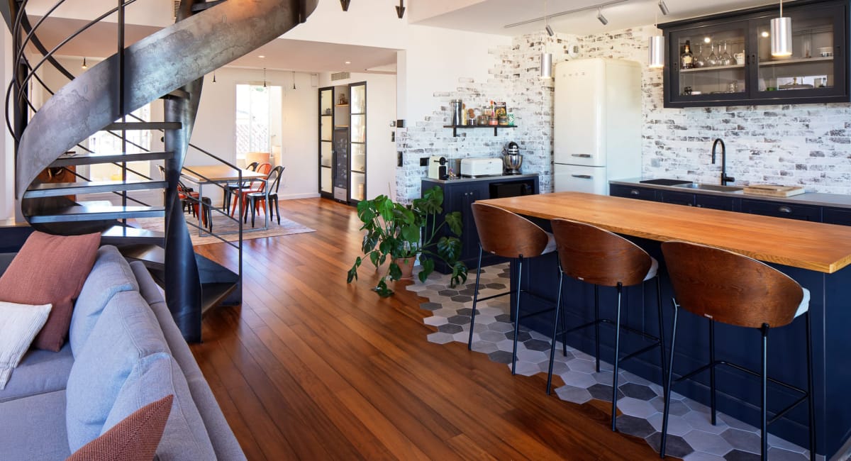 Intérieur moderne et chaleureux avec une cuisine design et une belle échelle en métal.