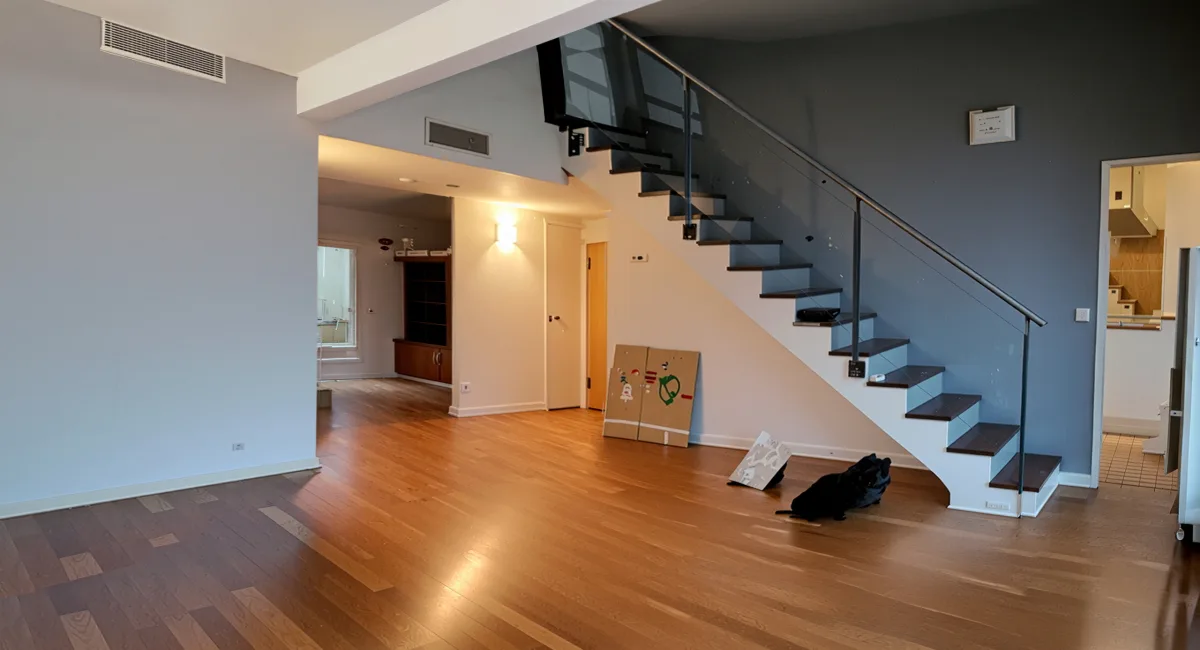 Intérieur d'un appartement avec escalier moderne et plancher en bois.