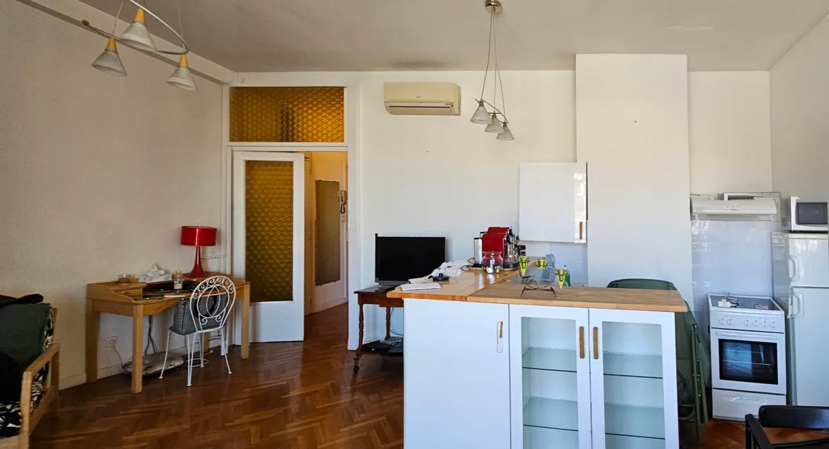 Intérieur d'un appartement moderne avec une cuisine et un espace de vie lumineux.