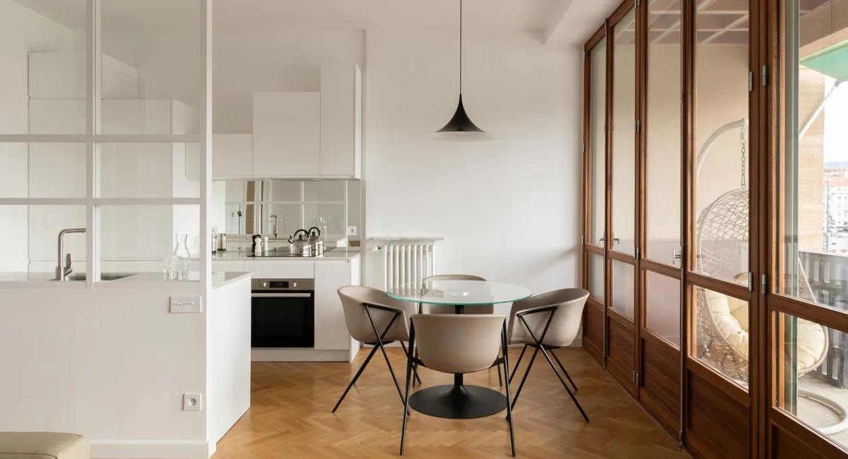 Cuisine moderne et lumineuse avec une belle table et vue sur la ville.