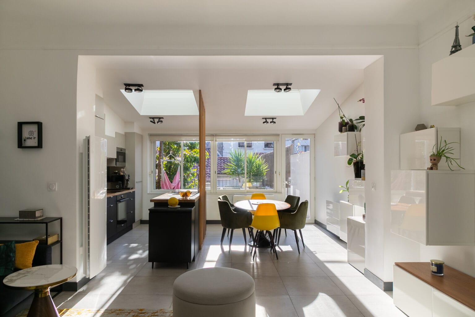 Intérieur lumineux d'une maison moderne avec une cuisine ouverte sur le salon.