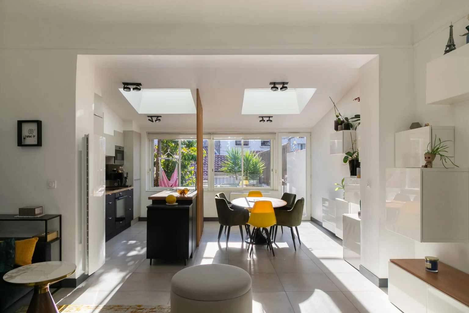 Intérieur lumineux d'une maison moderne avec une cuisine ouverte sur le salon.